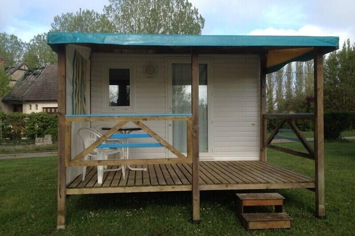 Eine kleine Holzhütte mit verdeckter Veranda und einem Fenster.