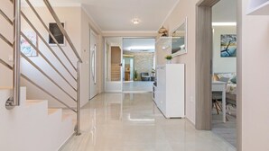 A modern interior with a staircase, a kitchen area, and a dining space. - Lovely home in Marcana with sauna (Marcana)