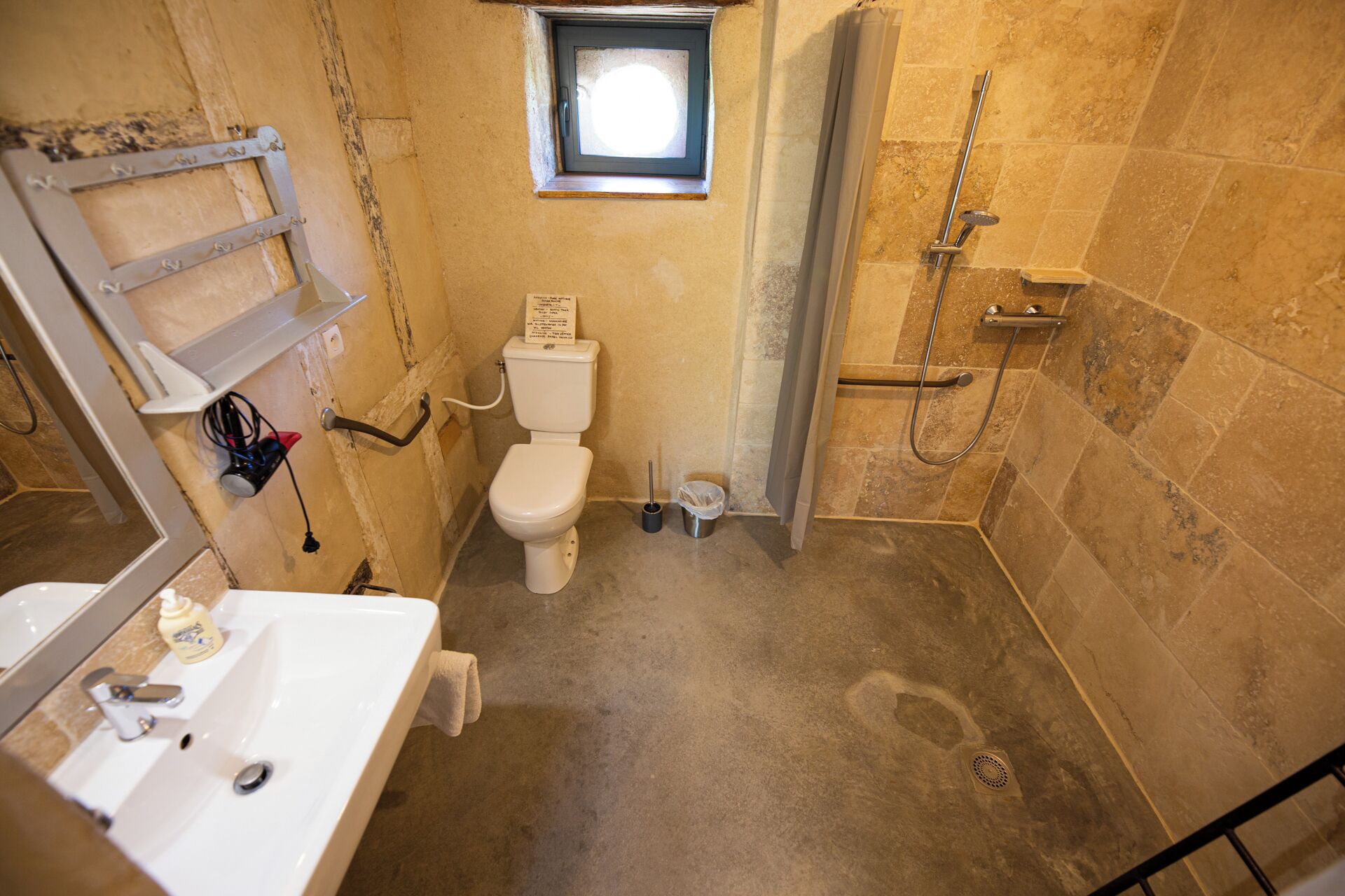 A small, compact bathroom with a toilet, sink, and shower.