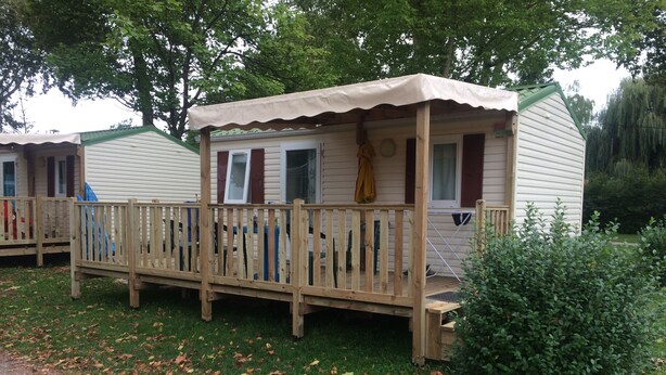 A mobile home with a wooden deck and a covered porch. - Ridorev (Auxonne)