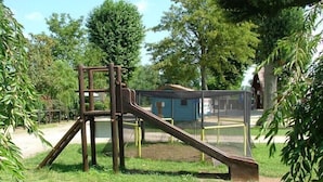 A playground with a slide and climbing structure surrounded by trees. - Amazone (Auxonne)