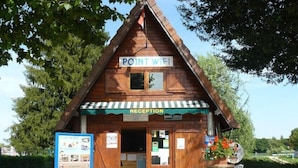 A wooden cabin with a reception area, labeled "POINT WIFI" and "RECEPTION," indicating a place for guests to check in and access Wi-Fi. - Amazone (Auxonne)