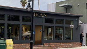 A building with the name "BEAN" on the facade, featuring large windows and a brick base. - Well-Furnished Oceanside Home! (Pismo Beach)