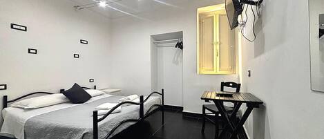 Un dormitorio pequeño y moderno con cama, escritorio y ventana.