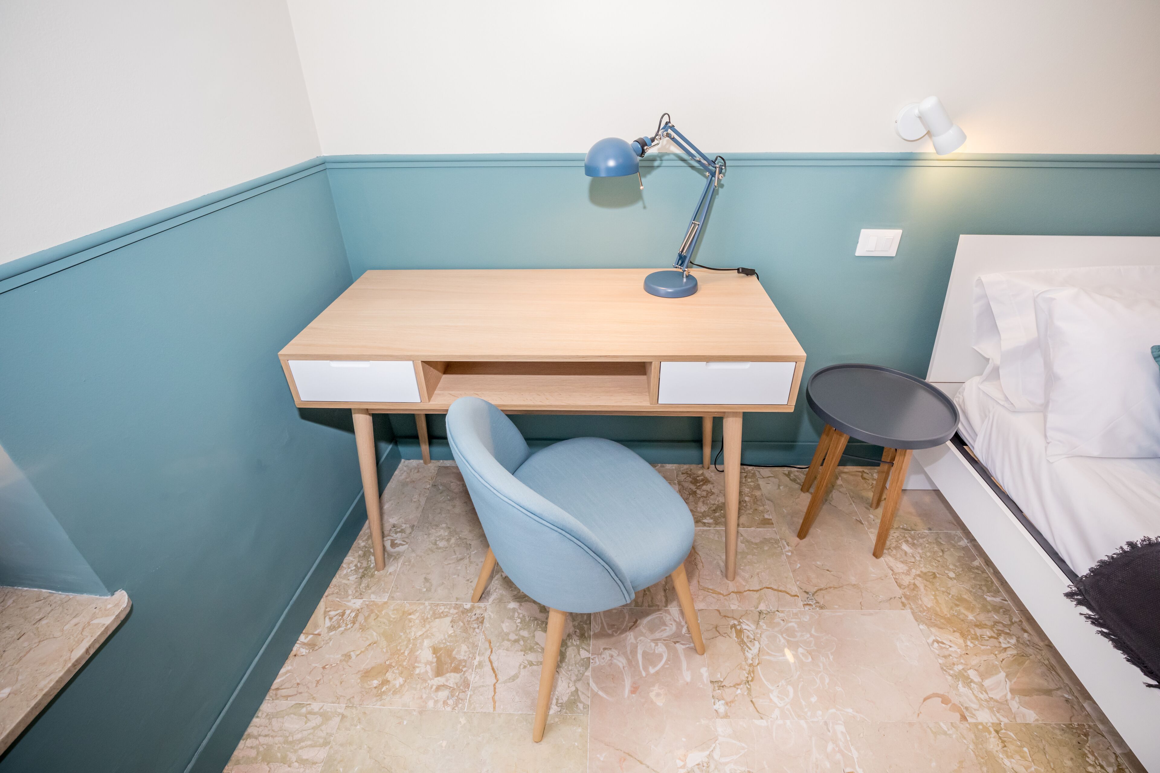 A room with a desk, chair, and bed.