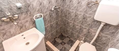 Ein Badezimmer mit Waschbecken, Toilette und Dusche.