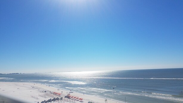 A beach with umbrellas and people. - Luxury Waterfront Condo Close to Fort Myers Beach and Golf Courses! (Fort Myers)