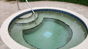 A circular pool with a tiled edge, a metal ladder, and a small water feature in the center. - Luxury Waterfront Condo Close to Fort Myers Beach and Golf Courses! (Fort Myers)