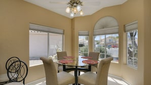 A dining area with a round table, four chairs, and a ceiling fan. - Spacious Southwestern Sunny Casita (Tucson)