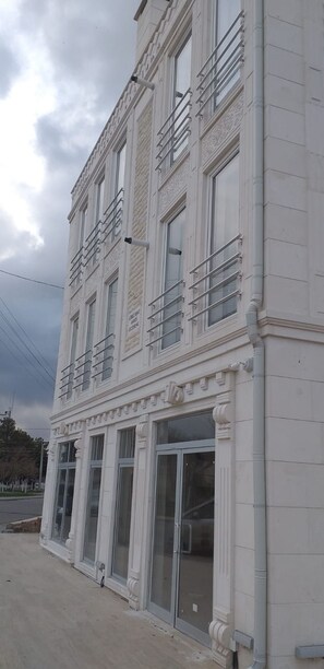 A multi-story building with large windows and decorative architectural elements. - Gurbuz Suite (Avanos)