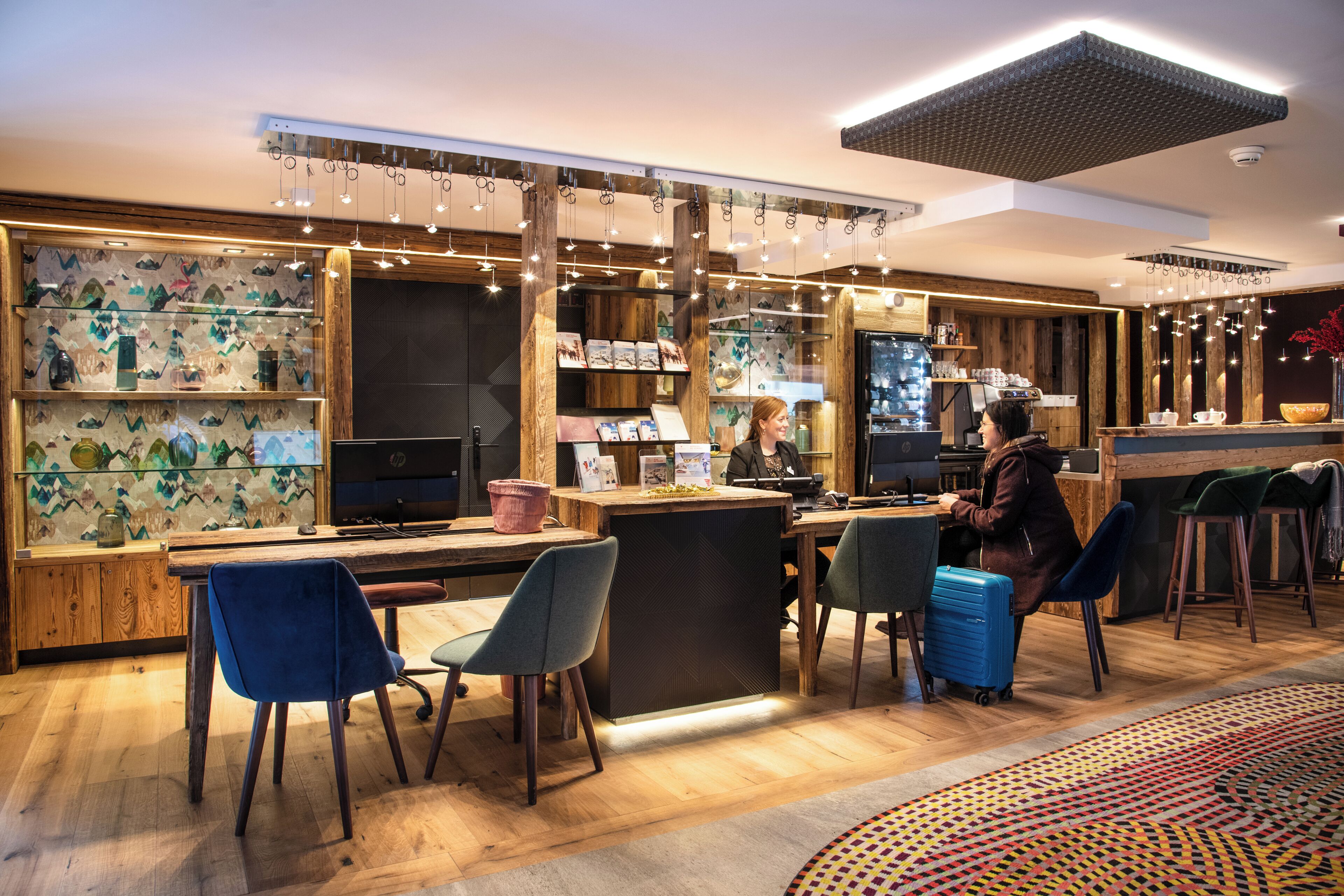 Eine moderne Hotelhalle mit Holzakzenten, einem Empfangsbereich und Sitzgelegenheiten.