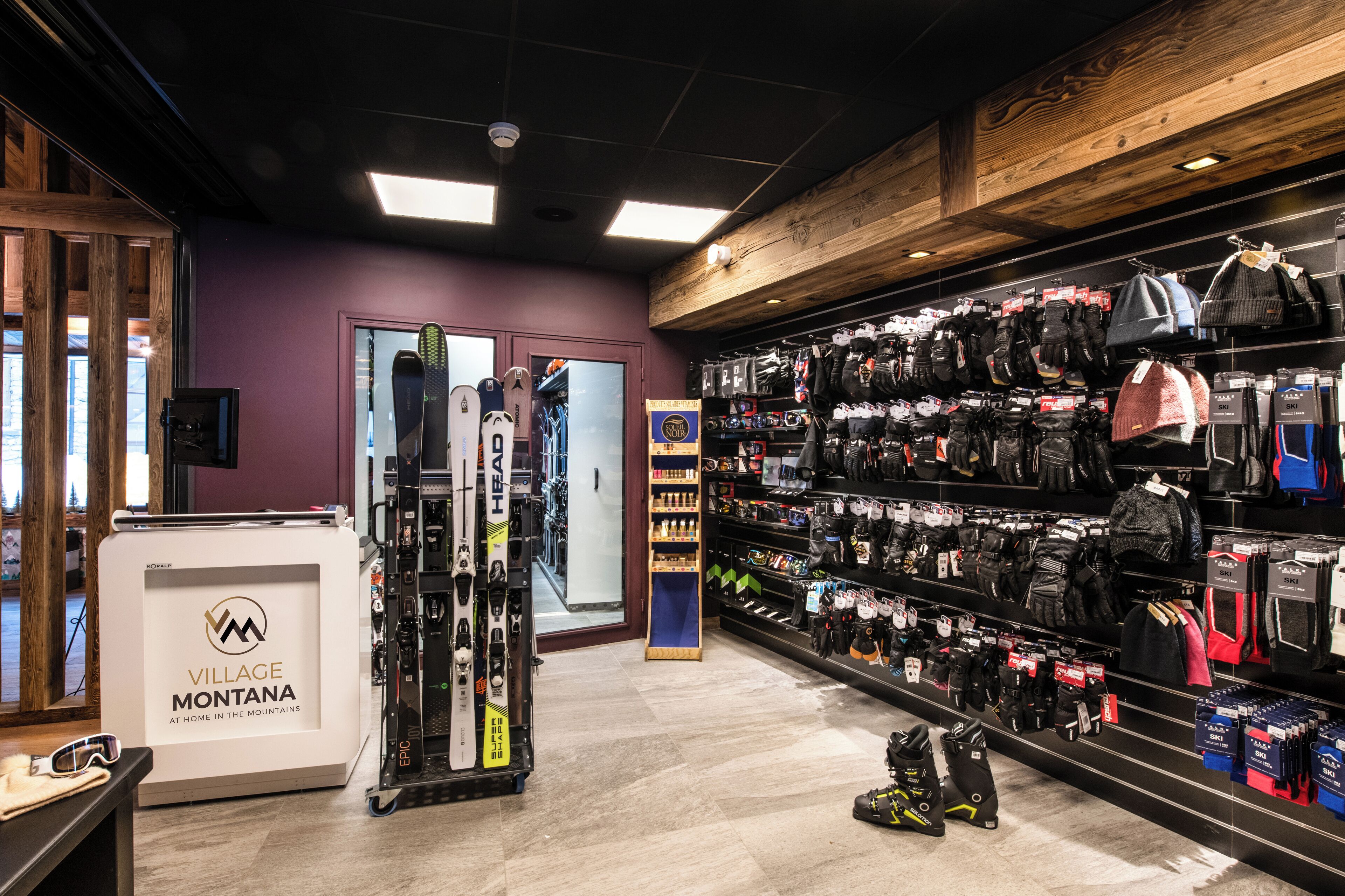 A ski equipment store with racks of skis, boots, and helmets.