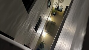 Um edifício alto com vários andares, cada um com uma varanda e uma pequena janela.