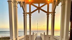 A wooden pier with a white bench at the end, leading to a view of the ocean. - Happy Hour Cottage Steps Away from Beach (Panama City Beach)