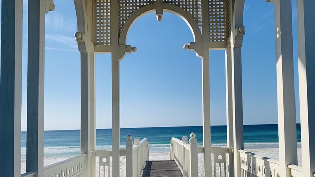 A wooden pier leading to a beach with a white gazebo structure. - Happy Hour Cottage Steps Away from Beach (Panama City Beach)