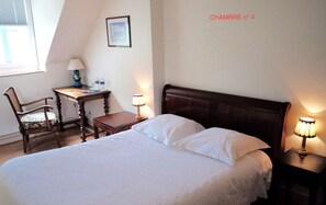 A bedroom with a bed, a desk, a chair, and two bedside lamps. - Les Chambres d'hôtes - Les Crépinières (Chartres)