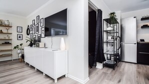 A modern living room with a white entertainment unit, a flat-screen TV, and a wall-mounted picture gallery. - Apartment V20 (Reykjavik)