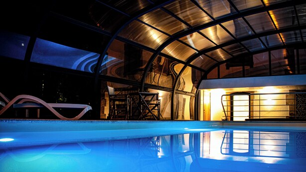 A modern indoor pool with a glass ceiling and metal framework. - Hotel Solar do Rebolo (Oliveira do Hospital)
