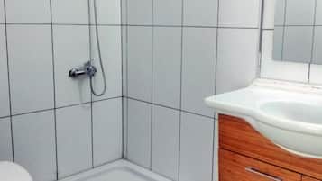 A bathroom with a shower, a toilet, and a vanity with a sink.