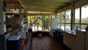Eine Küche mit großem Fenster, einer Spüle und einem Kühlschrank.