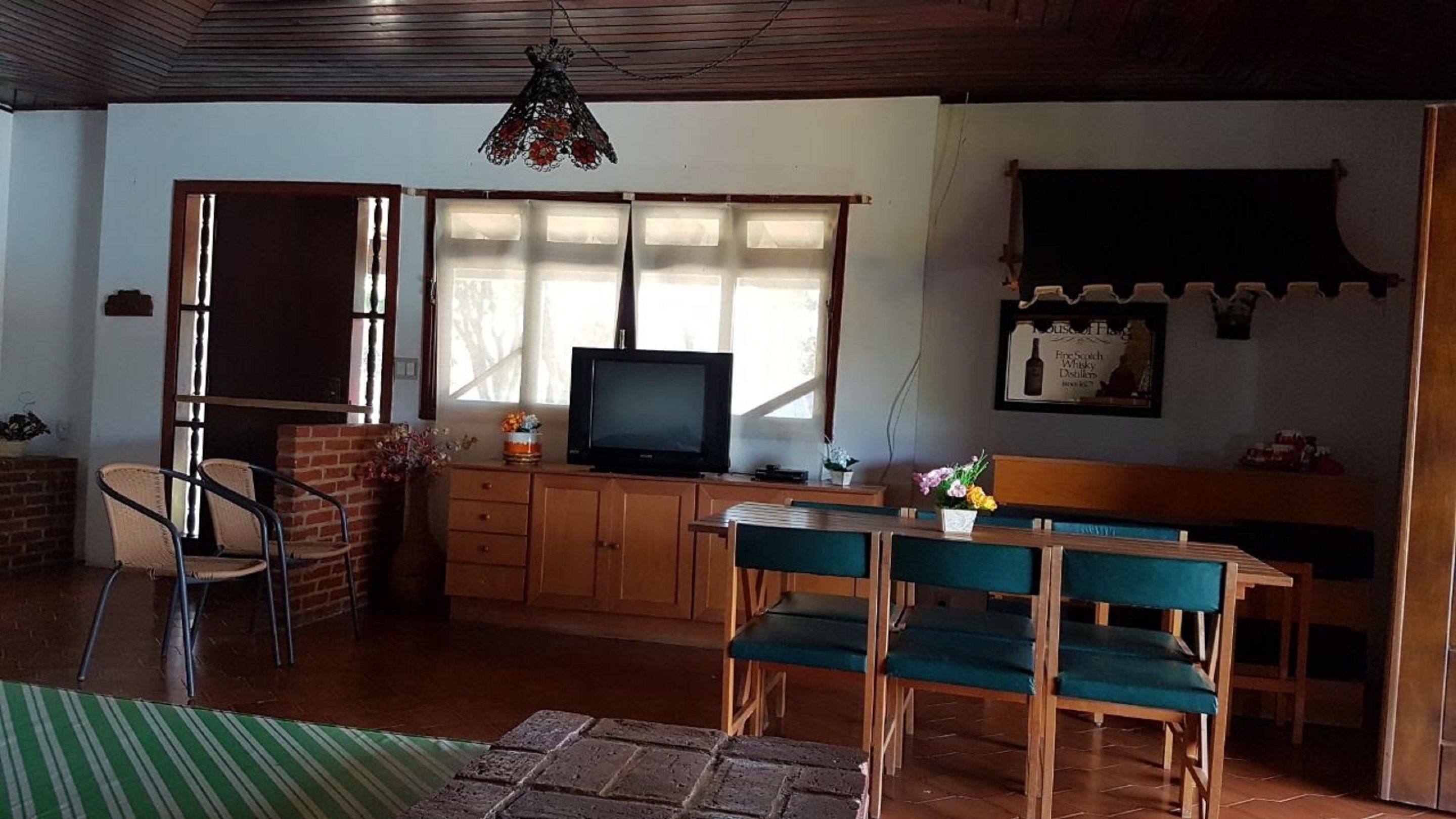 Una sala acogedora con televisor, muebles de madera y una chimenea de ladrillo.