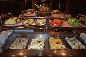 A buffet with various dishes, including salads, vegetables, and a fruit arrangement. - Bat Hotel Bistrica (East Sarajevo)