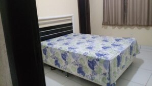 A bedroom with a bed, a door, and a window with curtains. - Casa em Armação de Búzios (Búzios)