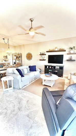 A living room with a sofa, coffee table, and a television.