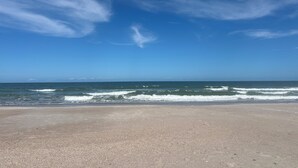 A beach with a clear sky and ocean waves. - July 27-Aug 1 open.  Modern Condo—Best location—beach, Ft Clinch & downtown. (Fernandina Beach)