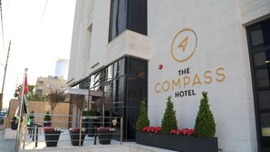 Hotel Compass con una fachada moderna, ventanas grandes y plantas en macetas.