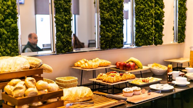 Un bufé con diversos productos horneados y frutas.