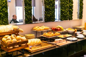 A buffet with various baked goods and fruits. - The Compass Hotel (Amman)