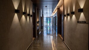 Un pasillo con luminarias modernas y un letrero que indica una sala de reuniones.