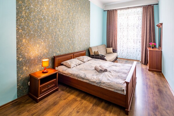 Relax in a classic bedroom with a large bed, nightstand, and lamp.