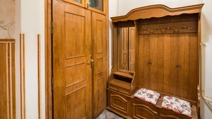 A wooden wardrobe with multiple doors and a bench with floral cushions. - Apartments on Square Rynok on Theatralna Street (Lviv)