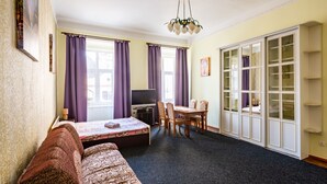 A room with a bed, a desk, a chair, a television, and a wardrobe. - Apartments on Square Rynok on Theatralna Street (Lviv)