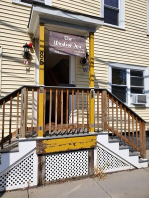 A two-story building with a wooden staircase leading to a porch. A sign above the entrance reads "The Windsor Inn." - The Windsor Inn (Cambridge)