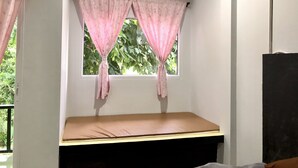 Una habitación con ventana, cama y equipo de aire acondicionado.