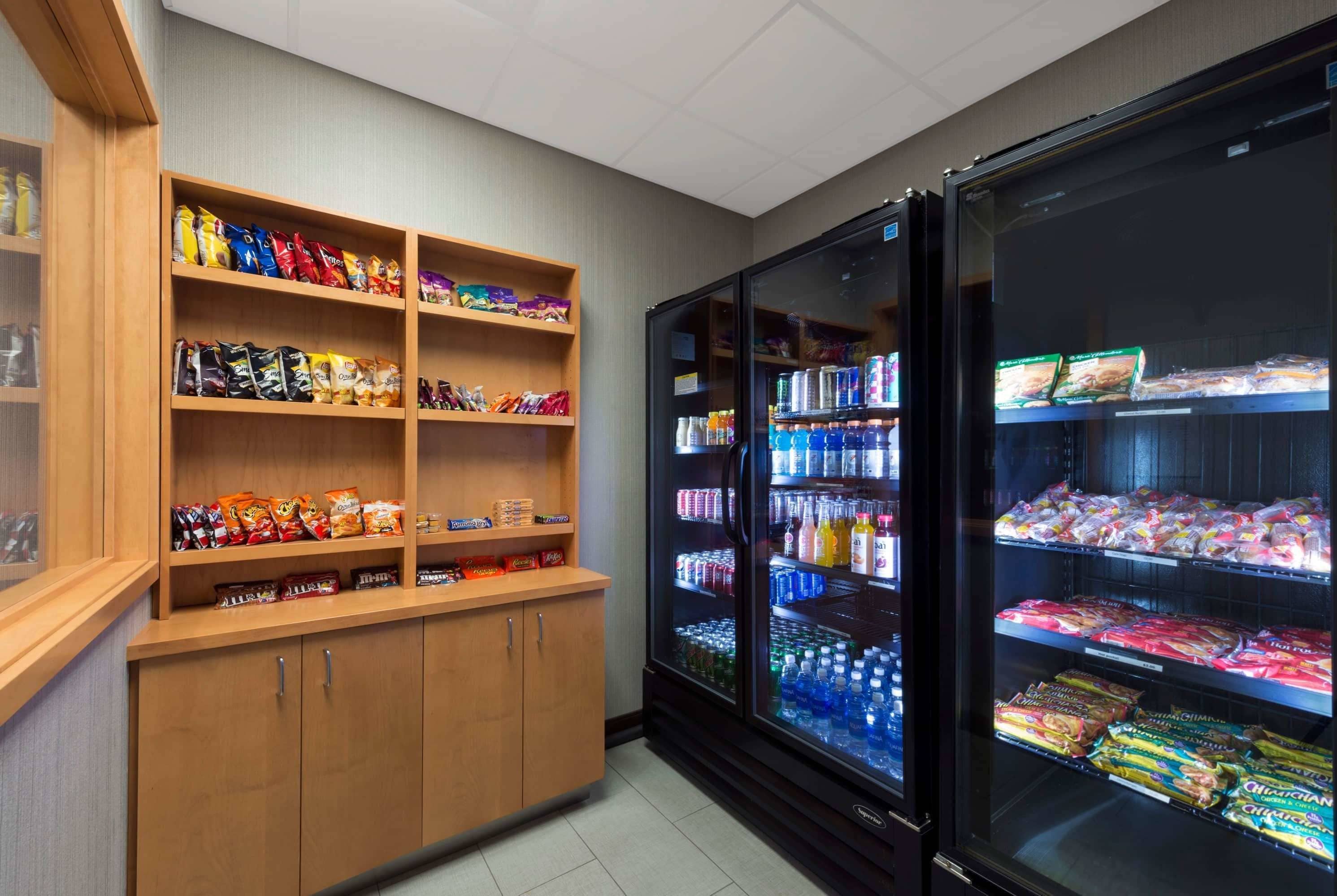 A snack and beverage vending area with shelves stocked with chips, snacks, and bottled drinks.