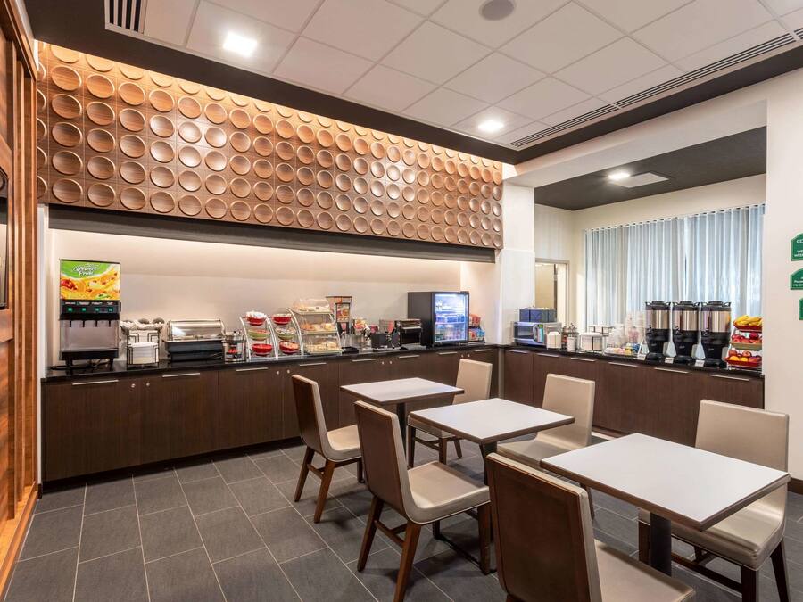 A modern cafe with a counter, seating area, and various food and drink options.