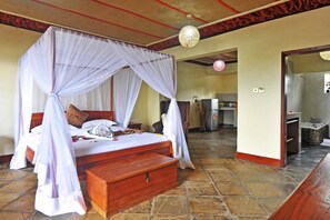 Quarto com cama de dossel, um banco de madeira e piso de ladrilho.