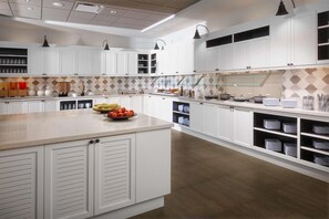 Una cocina moderna con armarios blancos, una isla central y un salpicadero con diseño.