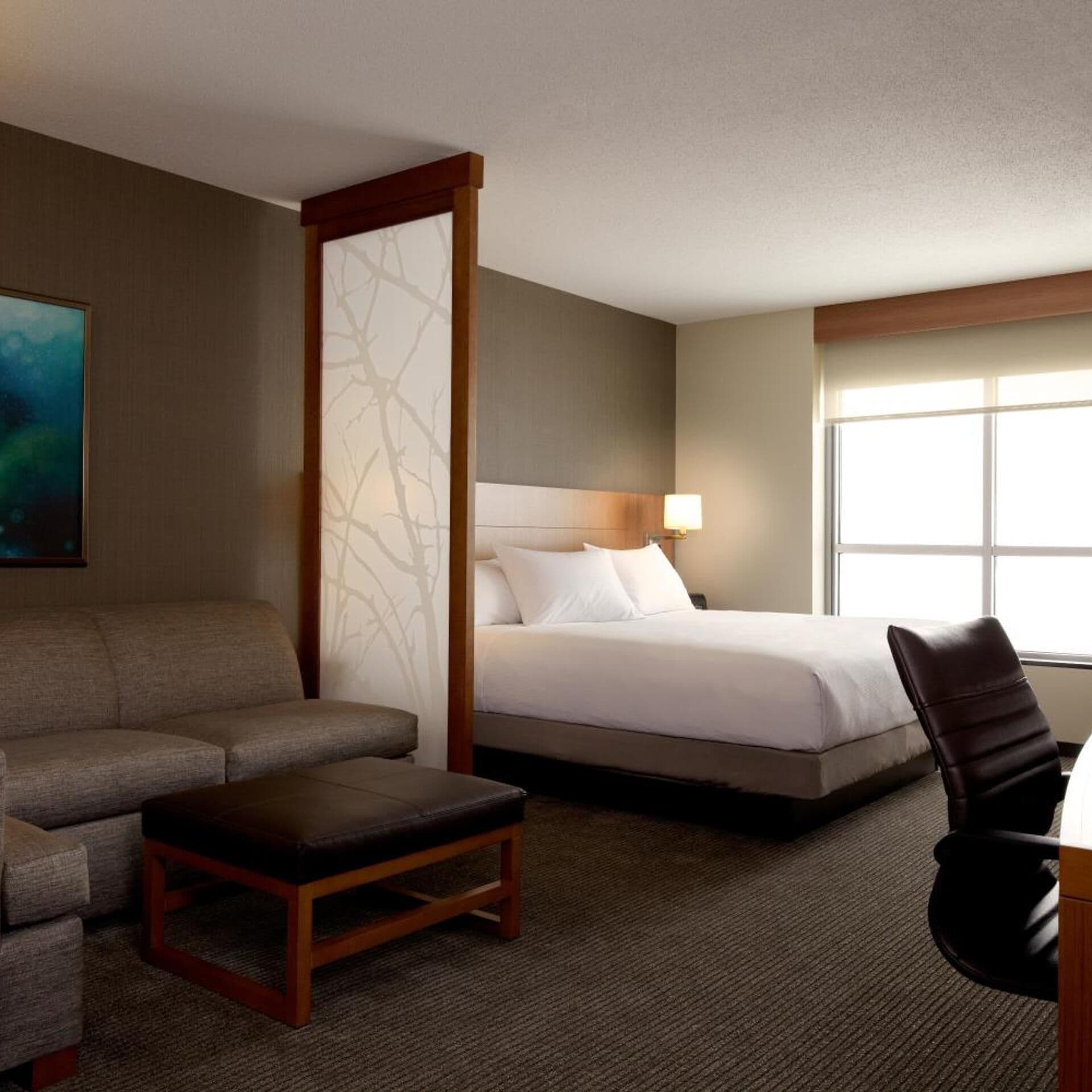 Een hotelkamer met een bed, een bank, een stoel en een bureau.