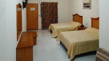 A room with two beds, a wooden bench, a door, and a curtain.