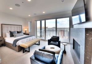 Une chambre d’hôtel moderne avec un grand lit, un canapé, une petite table et un téléviseur.