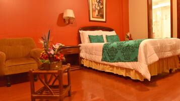 Una habitación de hotel con una cama de madera, una mesita de noche, una lámpara, una silla y un jarrón con flores.