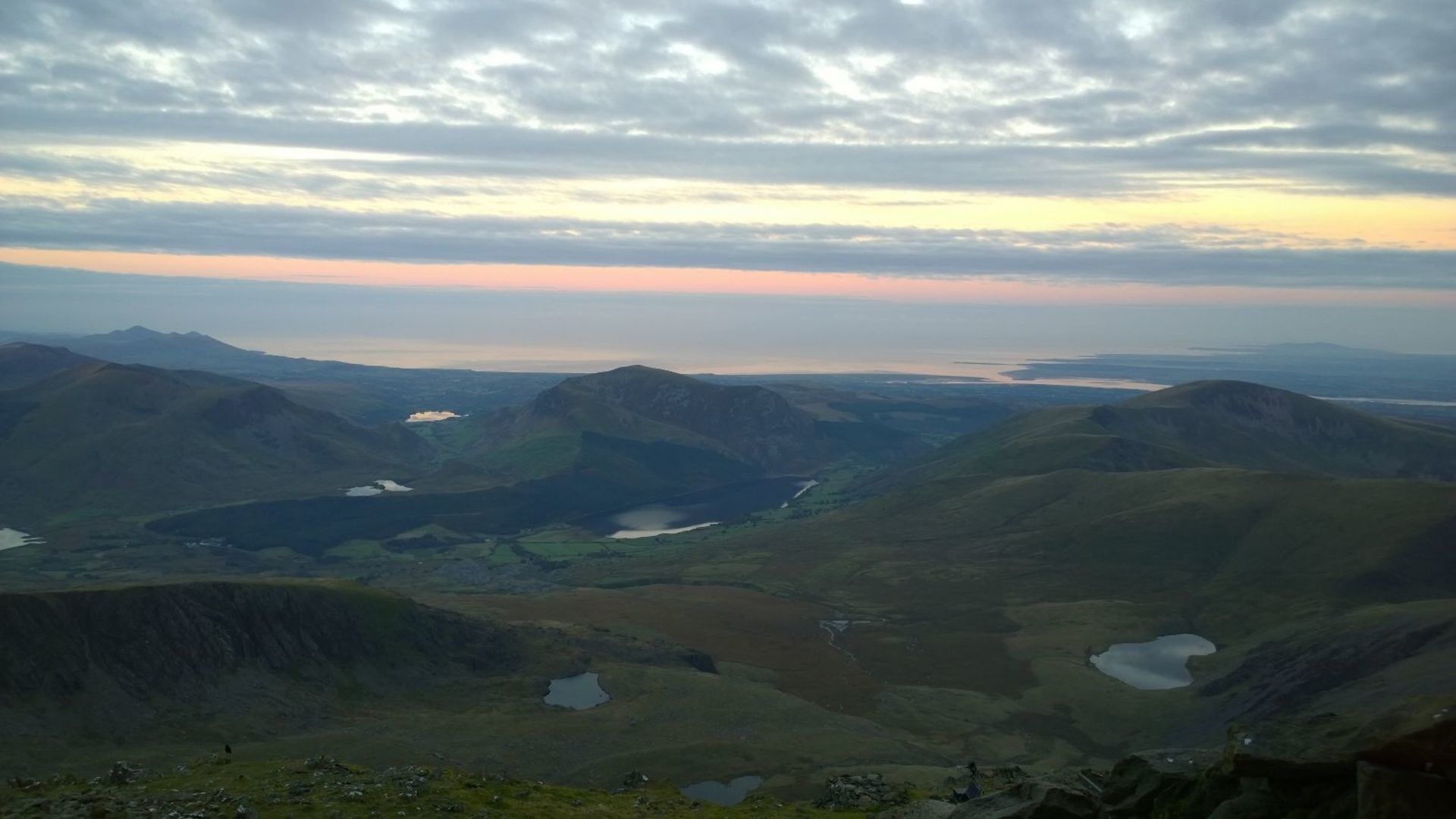 A panoramic view of a mountainous landscape with valleys and lakes.