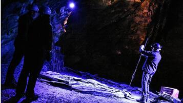 A cave with uneven rocky surfaces and a person holding a flashlight.