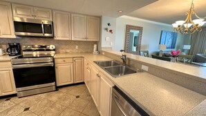 A modern kitchen with stainless steel appliances, a granite countertop, and a dishwasher.