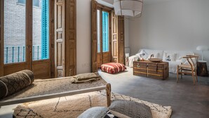 A spacious room with a large bed, a wooden chest, and a white sofa. - 2 balconies 2 fireplaces WITH CHARM and SPECIAL (Madrid)
